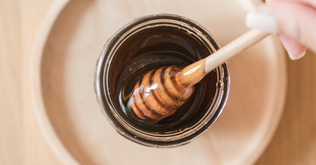 Top view of honey dipper in a jar, perfect for culinary and food themes.